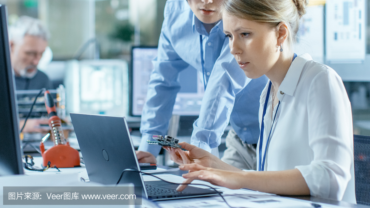 女計(jì)算機(jī)科學(xué)家將電路板連接到她的筆記本電腦并開(kāi)始編程。她在先進(jìn)技術(shù)實(shí)驗(yàn)室工作。